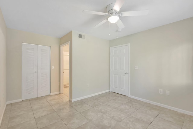 3693 NW Adriatic Ln, Jensen Beach, FL 34957 - unfurnished bedroom with a closet, a ceiling fan, light tile patterned flooring, and baseboards