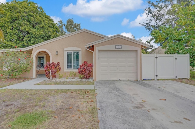 4641 Wadita Ka Way, West Palm Beach, FL 33417 - view of front of house featuring stucco siding, concrete driveway, a garage, and a gate