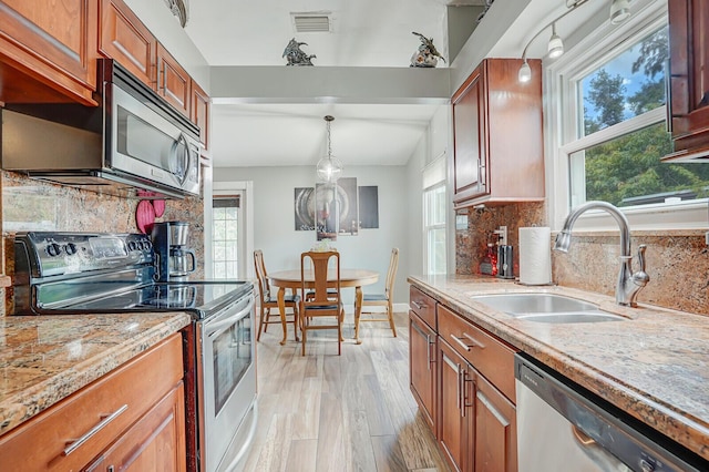 4641 Wadita Ka Way, West Palm Beach, FL 33417 - kitchen with appliances with stainless steel finishes, a sink, decorative backsplash, and brown cabinets