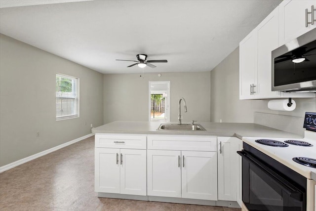 208 Olson Ave, Fort Pierce, FL 34946 - kitchen with range with electric stovetop, a sink, stainless steel microwave, a peninsula, and ceiling fan