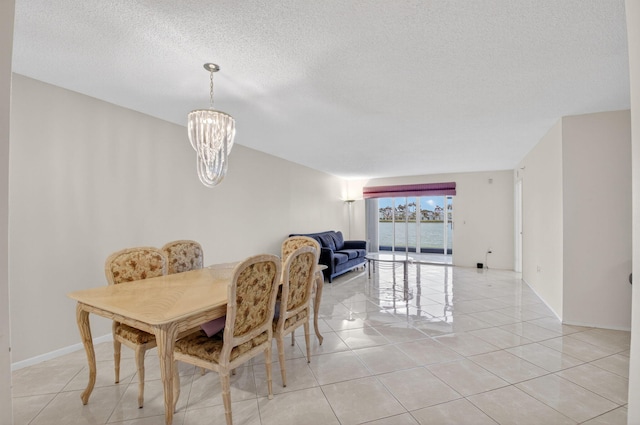 6112 Huntwick Ter Unit 106, Delray Beach, FL 33484 - dining space featuring light tile patterned floors, a chandelier, and a textured ceiling