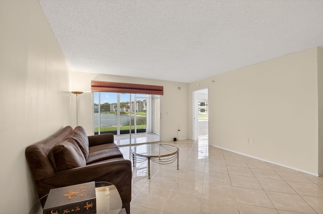6112 Huntwick Ter Unit 106, Delray Beach, FL 33484 - living area featuring a textured ceiling, light tile patterned floors, and a water view