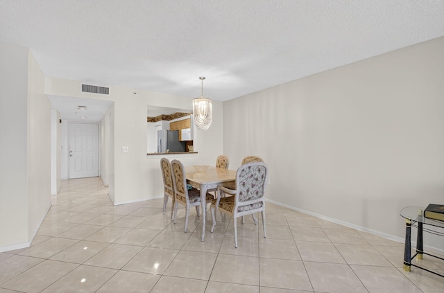 6112 Huntwick Ter Unit 106, Delray Beach, FL 33484 - dining area featuring light tile patterned flooring, a chandelier, and a textured ceiling