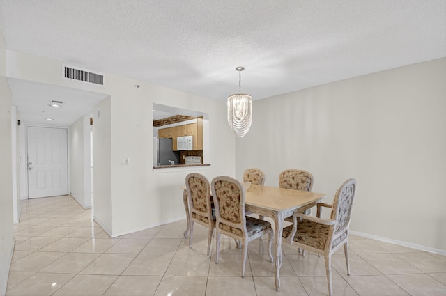 6112 Huntwick Ter Unit 106, Delray Beach, FL 33484 - dining space featuring a chandelier, light tile patterned floors, and a textured ceiling
