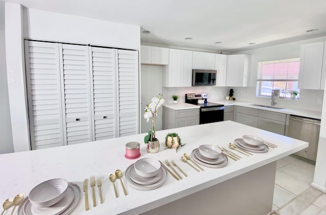 1430 SW 25th Way Unit B, Boynton Beach, FL 33426 - kitchen featuring appliances with stainless steel finishes, light countertops, white cabinetry, and light tile patterned floors