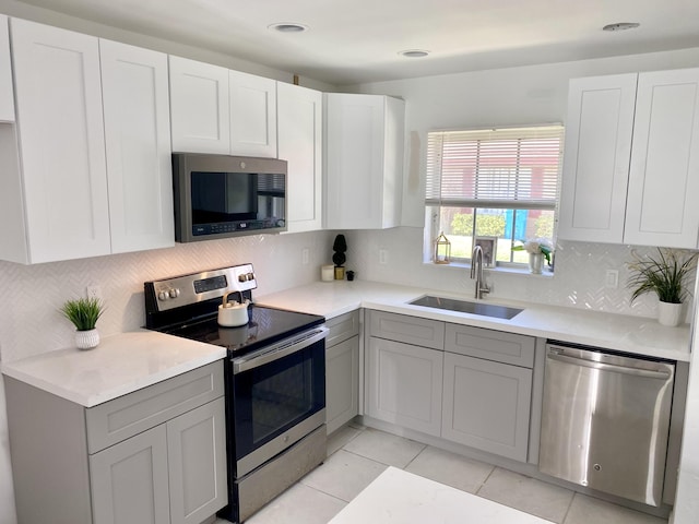 1430 SW 25th Way Unit B, Boynton Beach, FL 33426 - kitchen featuring stainless steel appliances, decorative backsplash, light countertops, white cabinetry, and recessed lighting