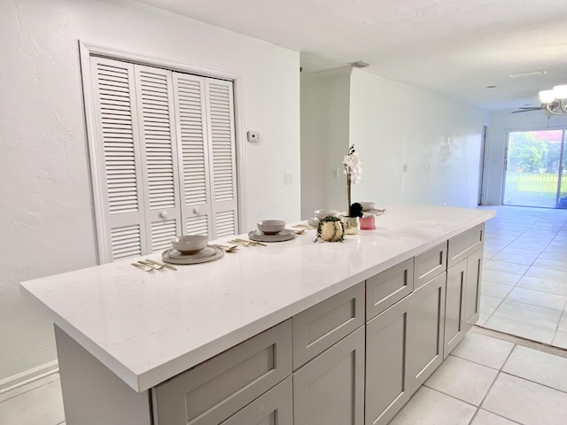 1430 SW 25th Way Unit B, Boynton Beach, FL 33426 - kitchen with gray cabinetry, a center island, light tile patterned floors, and light stone counters