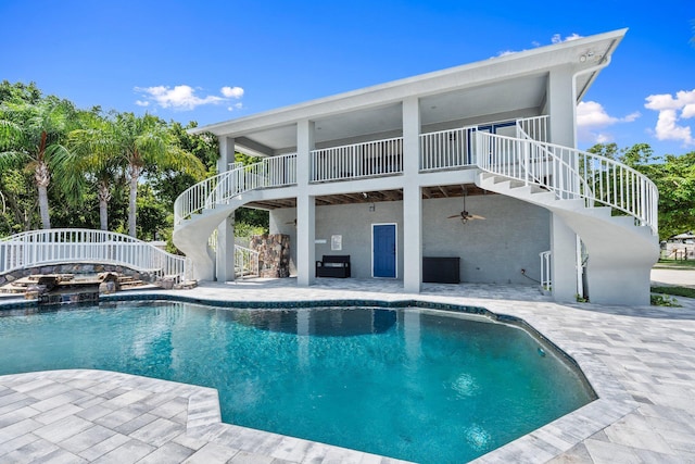 2130 W Boothe Dr, Fort Pierce, FL 34982 - rear view of house with stairs, a patio area, an outdoor pool, stucco siding, and a hot tub