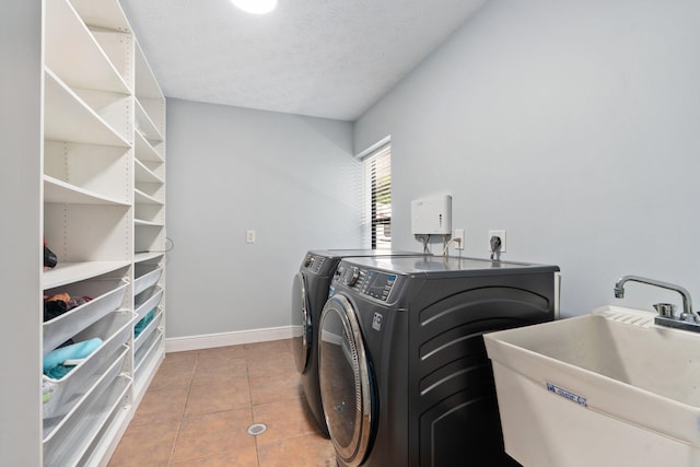 2130 W Boothe Dr, Fort Pierce, FL 34982 - laundry area with washing machine and clothes dryer, light tile patterned floors, baseboards, and a textured ceiling