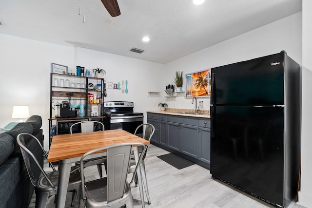 2130 W Boothe Dr, Fort Pierce, FL 34982 - kitchen featuring freestanding refrigerator, a sink, stainless steel electric range, light wood-type flooring, and light countertops