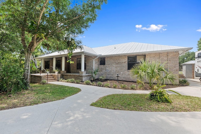 2130 W Boothe Dr, Fort Pierce, FL 34982 - ranch-style home featuring a porch, brick siding, and metal roof