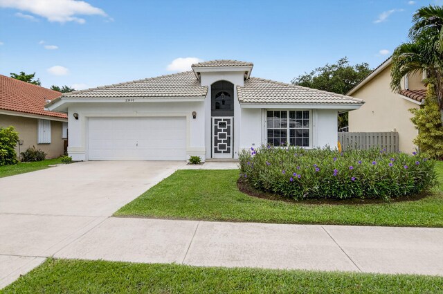 23440 Serene Meadow Dr S, Boca Raton, FL 33428 - mediterranean / spanish-style house featuring an attached garage, a tiled roof, stucco siding, driveway, and a front yard