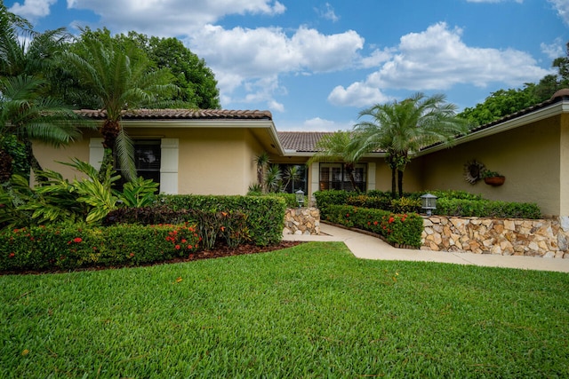 2413 NW 26th St, Boca Raton, FL 33431 - view of front of home with a tiled roof, stucco siding, and a front lawn