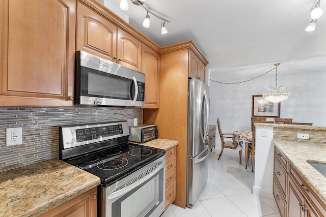 1009 N Ocean Blvd Unit 511, Pompano Beach, FL 33062 - kitchen featuring appliances with stainless steel finishes, light tile patterned floors, a chandelier, light stone countertops, and backsplash