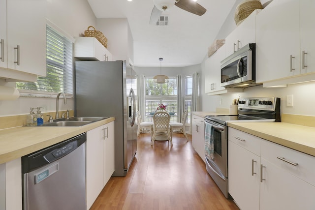 2633 SE Export Ave, Port Saint Lucie, FL 34952 - kitchen with stainless steel appliances, light wood-type flooring, and white cabinets