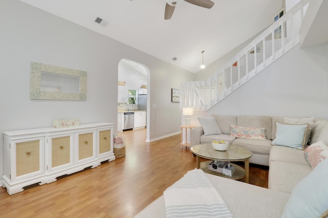 2633 SE Export Ave, Port Saint Lucie, FL 34952 - living area with light wood finished floors, a ceiling fan, arched walkways, and stairs
