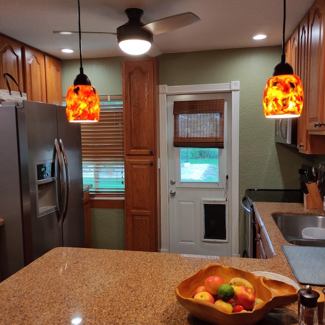 127 SW 12th Ave, Boynton Beach, FL 33435 - kitchen featuring stainless steel appliances, decorative light fixtures, a ceiling fan, brown cabinets, and a textured wall