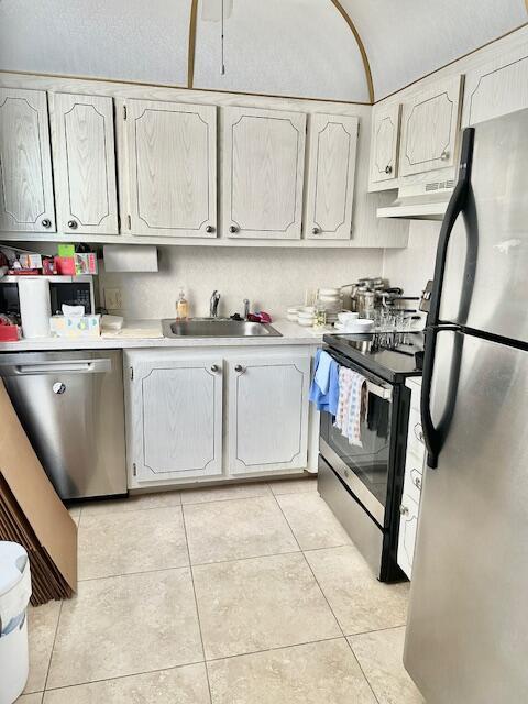 187 Preston E, Boca Raton, FL 33434 - kitchen with appliances with stainless steel finishes, under cabinet range hood, a sink, light countertops, and light tile patterned floors