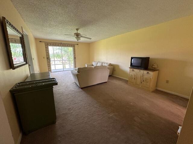 1947 SW Palm City Rd Unit G, Stuart, FL 34994 - living area with ceiling fan, a textured ceiling, carpet flooring, and baseboards