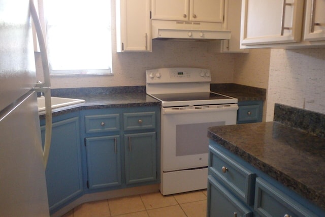 1947 SW Palm City Rd Unit G, Stuart, FL 34994 - kitchen with white range with electric cooktop, freestanding refrigerator, under cabinet range hood, and blue cabinets