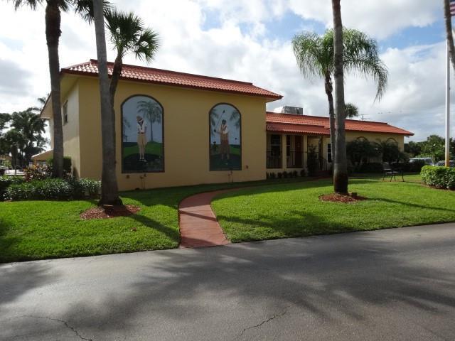1947 SW Palm City Rd Unit G, Stuart, FL 34994 - mediterranean / spanish-style home featuring a tile roof, stucco siding, and a front yard