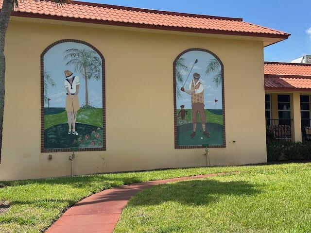 1947 SW Palm City Rd Unit G, Stuart, FL 34994 - view of side of home with a tile roof, stucco siding, and a yard