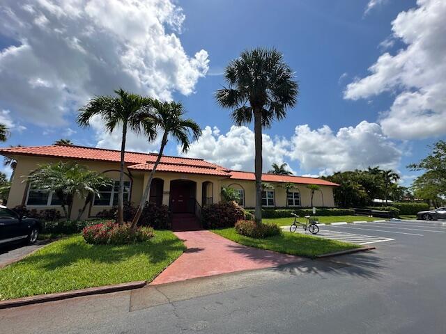 1947 SW Palm City Rd Unit G, Stuart, FL 34994 - mediterranean / spanish home featuring stucco siding, a front lawn, and a tiled roof