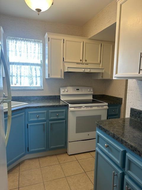 1947 SW Palm City Rd Unit G, Stuart, FL 34994 - kitchen featuring white range with electric cooktop, under cabinet range hood, blue cabinetry, white cabinets, and dark countertops