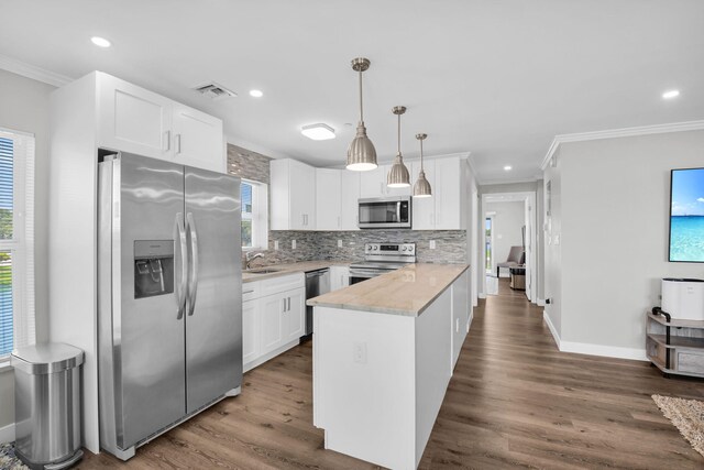 388 Tuscany G 388, Delray Beach, FL 33446 - kitchen featuring stainless steel appliances, ornamental molding, a peninsula, tasteful backsplash, and healthy amount of natural light