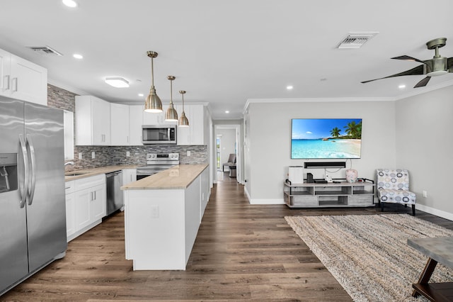 388 Tuscany G 388, Delray Beach, FL 33446 - kitchen featuring stainless steel appliances, crown molding, baseboards, white cabinets, and recessed lighting