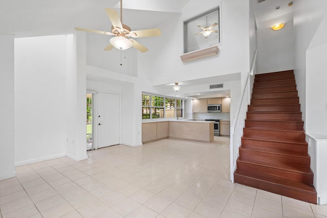 8111 Northboro Ct Unit 11B, Lake Clarke Shores, FL 33406 - entryway featuring a towering ceiling, stairs, ceiling fan, light tile patterned flooring, and baseboards