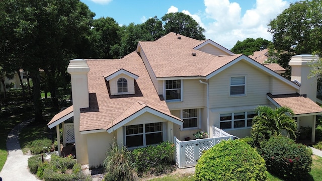 8111 Northboro Ct Unit 11B, Lake Clarke Shores, FL 33406 - back of property with a shingled roof, a chimney, an attached garage, and stucco siding