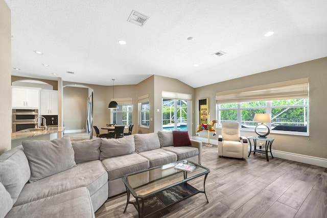 21480 Halstead Dr, Boca Raton, FL 33428 - living room featuring arched walkways, recessed lighting, wood finished floors, and a textured ceiling