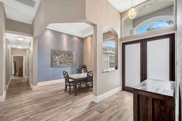 21480 Halstead Dr, Boca Raton, FL 33428 - entryway with light wood finished floors, a textured wall, and arched walkways