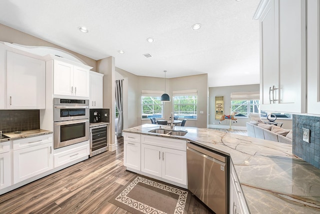 21480 Halstead Dr, Boca Raton, FL 33428 - kitchen featuring stainless steel appliances, beverage cooler, light wood-type flooring, white cabinets, and decorative backsplash