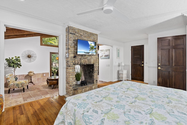 2070 Spring Pl, Vero Beach, FL 32963 - bedroom featuring wood finished floors, a brick fireplace, crown molding, ceiling fan, and a textured ceiling