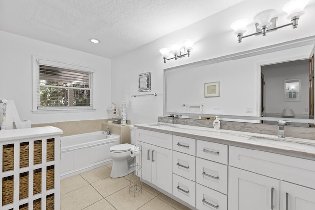 2070 Spring Pl, Vero Beach, FL 32963 - bathroom featuring double vanity, tile patterned floors, a garden tub, toilet, and a textured ceiling