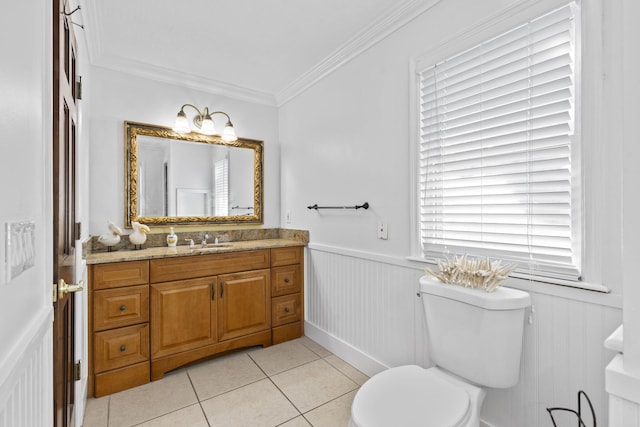 2070 Spring Pl, Vero Beach, FL 32963 - bathroom featuring toilet, vanity, tile patterned flooring, crown molding, and a wainscoted wall