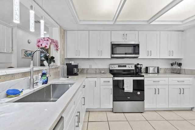 2070 Spring Pl, Vero Beach, FL 32963 - kitchen with appliances with stainless steel finishes, a sink, light tile patterned flooring, white cabinets, and light stone countertops