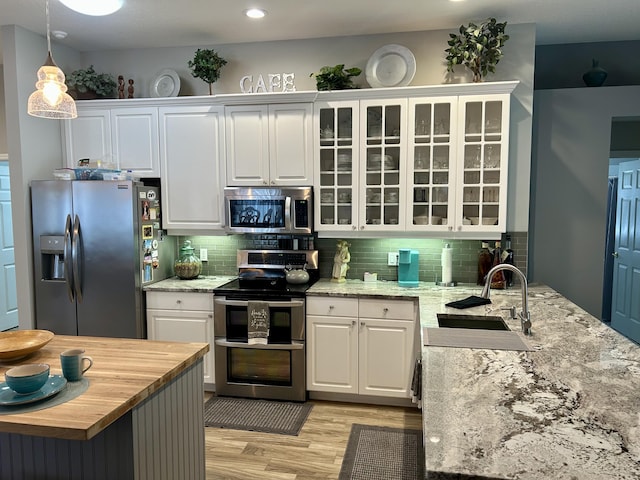 644 NW San Candido Way, Port Saint Lucie, FL 34986 - kitchen featuring appliances with stainless steel finishes, a sink, wood counters, white cabinetry, and light wood-style floors