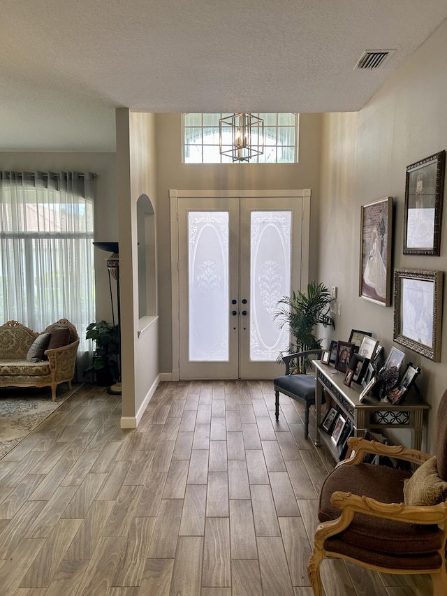 644 NW San Candido Way, Port Saint Lucie, FL 34986 - entrance foyer featuring wood finished floors, plenty of natural light, a chandelier, and a textured ceiling