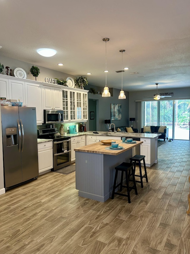 644 NW San Candido Way, Port Saint Lucie, FL 34986 - kitchen featuring stainless steel appliances, a peninsula, light wood-type flooring, butcher block counters, and recessed lighting