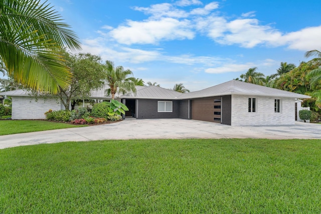 1772 SW Commodore Pl, Palm City, FL 34990 - view of front facade with an attached garage, a front yard, concrete driveway, and metal roof