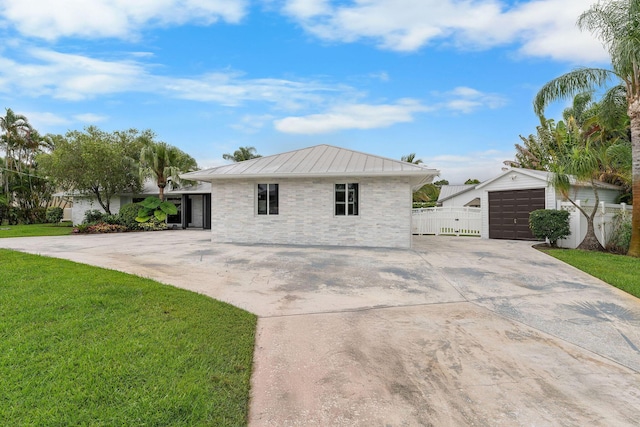 1772 SW Commodore Pl, Palm City, FL 34990 - view of front of property featuring driveway, an outdoor structure, a standing seam roof, metal roof, and a garage