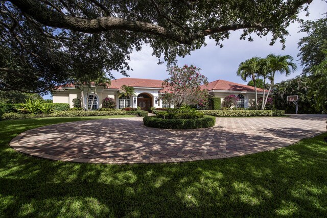 7656 Steeplechase Dr, Palm Beach Gardens, FL 33418 - view of front facade with curved driveway, a front lawn, and stucco siding