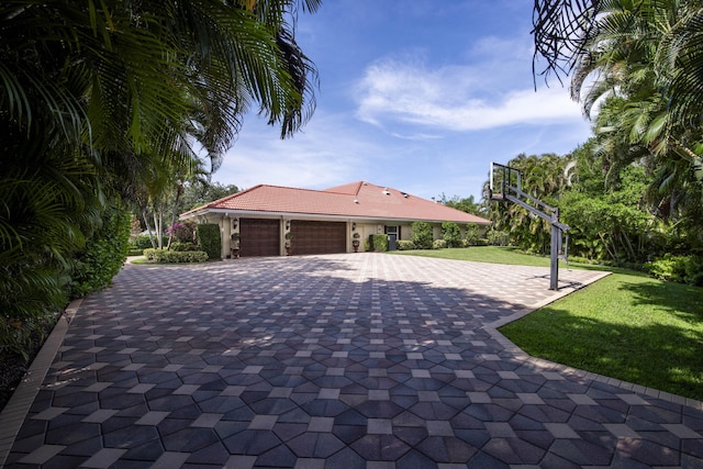 7656 Steeplechase Dr, Palm Beach Gardens, FL 33418 - view of side of property with a lawn, a garage, decorative driveway, and a tiled roof