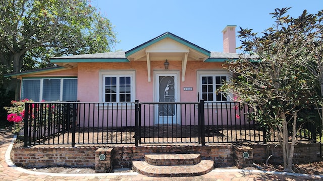 1709 N Palmway, Lake Worth Beach, FL 33460 - view of front facade with stucco siding, a chimney, and a shingled roof