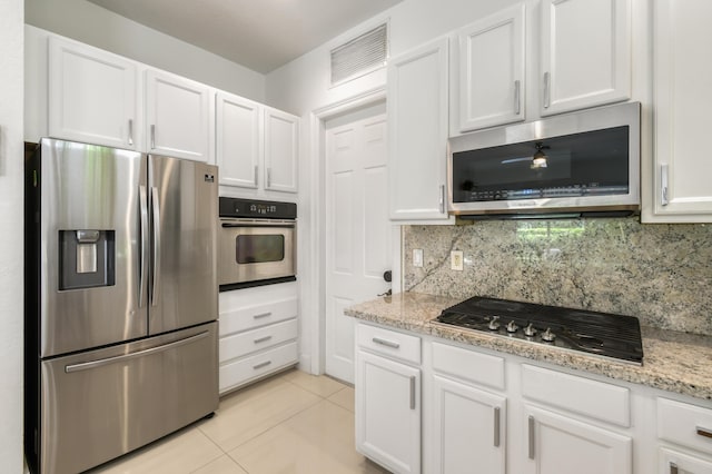 1522 Carafe Ct, Palm Beach Gardens, FL 33410 - kitchen with appliances with stainless steel finishes, white cabinets, backsplash, and light tile patterned floors