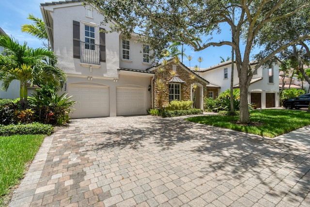 1522 Carafe Ct, Palm Beach Gardens, FL 33410 - mediterranean / spanish house featuring a garage, decorative driveway, stucco siding, and a balcony