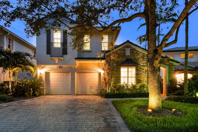 1522 Carafe Ct, Palm Beach Gardens, FL 33410 - mediterranean / spanish house with a garage, decorative driveway, stone siding, and stucco siding